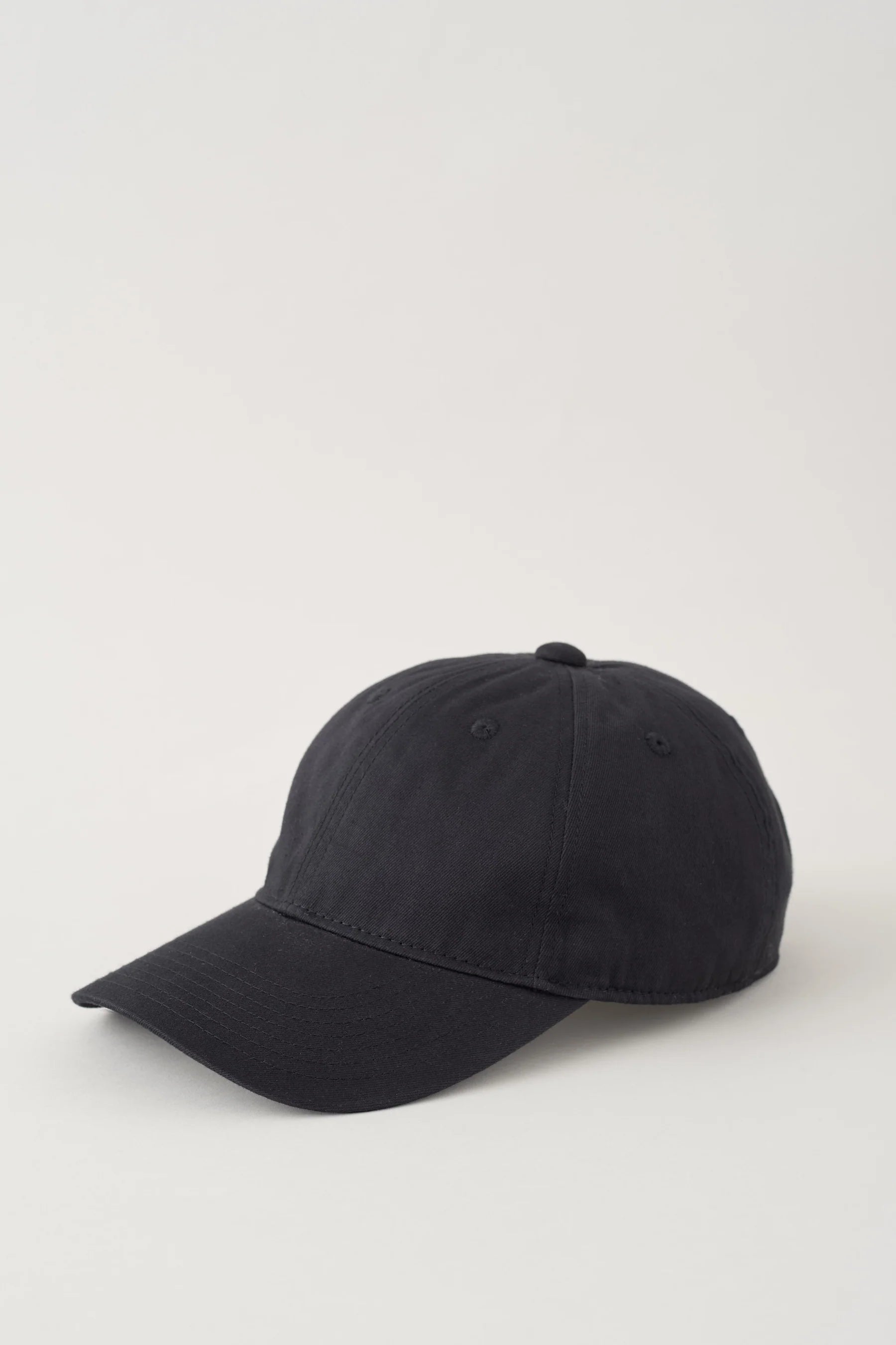 Black baseball cap on a light gray background